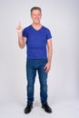 Full body shot of happy mature man pointing up against white background Royalty Free Stock Photo