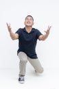 Full body shot of a middle aged asian man kneeling down ready to catch someone falling down. Isolated agaisnt a white background