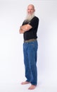 Full body shot profile view of happy mature bald bearded man looking at camera Royalty Free Stock Photo