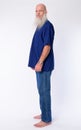 Full body shot profile view of mature bald bearded man looking at camera Royalty Free Stock Photo