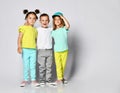 Full body shot of three children in bright clothes, two girls and one boy. Triplets, brother and sisters.