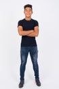 Full body shot of young happy Asian man against white background Royalty Free Stock Photo