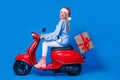 Full body side photo of good mood santa claus courier happy new year spirit vibe delivery moped gift box isolated on