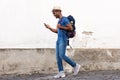 Side portrait of happy african american tourist man walking with bag and cellphone Royalty Free Stock Photo