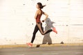 Full body healthy young woman sprinting outdoors in the city Royalty Free Stock Photo