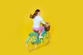 Full body size back photo of pretty charming young girl ride retro bicycle ride through neighborhood carry flowers wear Royalty Free Stock Photo