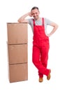 Full body of smiling mover guy leaning on boxes Royalty Free Stock Photo