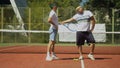 Tennis players posing near net on court