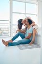 Full body young mixed race couple sitting together and bonding in their bedroom at home. Hispanic woman on a bed Royalty Free Stock Photo