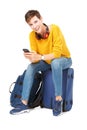 Full body young travel woman sitting on suitcase and holding cellphone Royalty Free Stock Photo