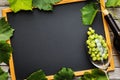 Full bottle of wine with a glass, bunch of grapes and leaves on a wooden table with copy space Royalty Free Stock Photo