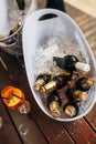 Tivat, Montenegro - 29 july 2020: Full bottles of beer in ice buckets on a wooden surface with a glass of orange drink