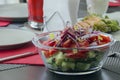 Full bowl of fresh salad close up on a black table.