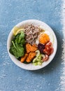 Full bowl healthy food - buckwheat, baked sweet potatoes, spinach, egg, beetroot, celery, tomatoes. Delicious diet lunch on blue b Royalty Free Stock Photo