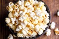 A full bowl of popcorn and on a wooden background. Royalty Free Stock Photo