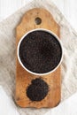 Full bowl of raw organic black quinoa on rustic wooden board, view from above. Flat lay, overhead, top view Royalty Free Stock Photo