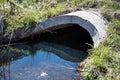 full capacity concrete culvert with sheen contaminated storm water runoff Royalty Free Stock Photo