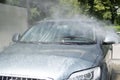 Full car wash at the self service. Splashed drops of water from a sprayer washing the car. Windshield. White foam Royalty Free Stock Photo