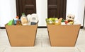 The full cardboard eco box with products from the grocery store on the floor