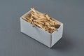 Full cardboard matchbox of many used matchsticks on dark concrete table on kitchen