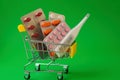A full cart from the pharmacy with medicines and pills on a green background Royalty Free Stock Photo