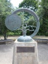 circular sculpture with bare tree, and a coin medallion with children playing