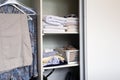 Full closet with clothes and Stack of towels in white wooden closet, organization and storage Royalty Free Stock Photo