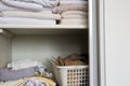 Full closet with clothes and Stack of towels in white wooden closet, organization and storage Royalty Free Stock Photo