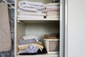 Full closet with clothes and Stack of towels in white wooden closet, organization and storage Royalty Free Stock Photo