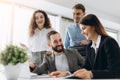 Full concentration at work. Group of young business people working and communicating while sitting at the office desk together Royalty Free Stock Photo