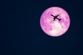 Full Crow Moon and silhouette airplane flight on night sky Royalty Free Stock Photo