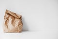 Full crumpled disposable bag of brown kraft paper on a white background. Copy, empty space for text