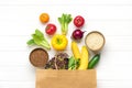 Full eco paper bag of different health food - buckwheat, rice, yellow bell pepper, tomatoes, bananas, lettuce, green, cucumber, on Royalty Free Stock Photo