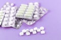 Full and empty packs of white capsules and pills packed in blisters with copy space on purple background. Focus on foreground, sof Royalty Free Stock Photo