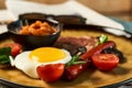 Full English breakfast with bacon, sausage, fried egg, baked beans Royalty Free Stock Photo