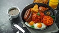 Full English breakfast with bacon, sausage, fried egg, baked beans, hash browns and mushrooms in rustic skillet, pan Royalty Free Stock Photo