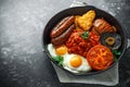 Full English breakfast with bacon, sausage, fried egg, baked beans, hash browns and mushrooms in rustic skillet, pan. Royalty Free Stock Photo