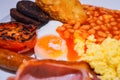 Full English Breakfast with Bacon, Sausage, Fried Egg, Beans, Scrambled Eggs, Hash Browns and Black Pudding. Royalty Free Stock Photo