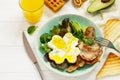 Full English breakfast - fried egg, fried bacon, spinach, arugula, avocado, toast and orange juice. Royalty Free Stock Photo