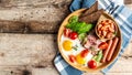 Full English Breakfast with fried eggs, bacon, beans, toasts, tomatoes, sausages and avocado on wooden background. Top view, Royalty Free Stock Photo