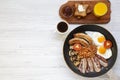 Full English breakfast in a pan with fried eggs, bacon, sausages, beans and toasts on white wooden background, top view. Copy spac Royalty Free Stock Photo