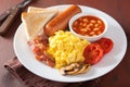 Full english breakfast with scrambled eggs, bacon, sausage, bean Royalty Free Stock Photo