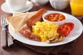 Full english breakfast with scrambled eggs, bacon, sausage, bean Royalty Free Stock Photo