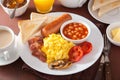 Full english breakfast with scrambled eggs, bacon, sausage, bean Royalty Free Stock Photo