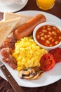 Full english breakfast with scrambled eggs, bacon, sausage, bean Royalty Free Stock Photo