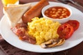 Full english breakfast with scrambled eggs, bacon, sausage, bean Royalty Free Stock Photo