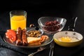 Full English breakfast with scrambled eggs in a frying pan, bacon, sausage, beans, tomatoes and juice Royalty Free Stock Photo