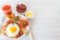 Full English breakfast with smoked sausages, scrambled eggs, bacon, tomatoes, mushrooms, toast and beans. A glass of fresh juice. Royalty Free Stock Photo