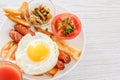 Full English breakfast with smoked sausages, scrambled eggs, bacon, tomatoes, mushrooms, toast and beans. A glass of fresh juice. Royalty Free Stock Photo
