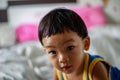 A Full Face of Adorable toddler Asian baby boy 2-year-old Relaxing and Looking Camera in the Room with Blurry Background, Home Royalty Free Stock Photo